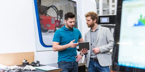 Dos hombres conversando frente robot